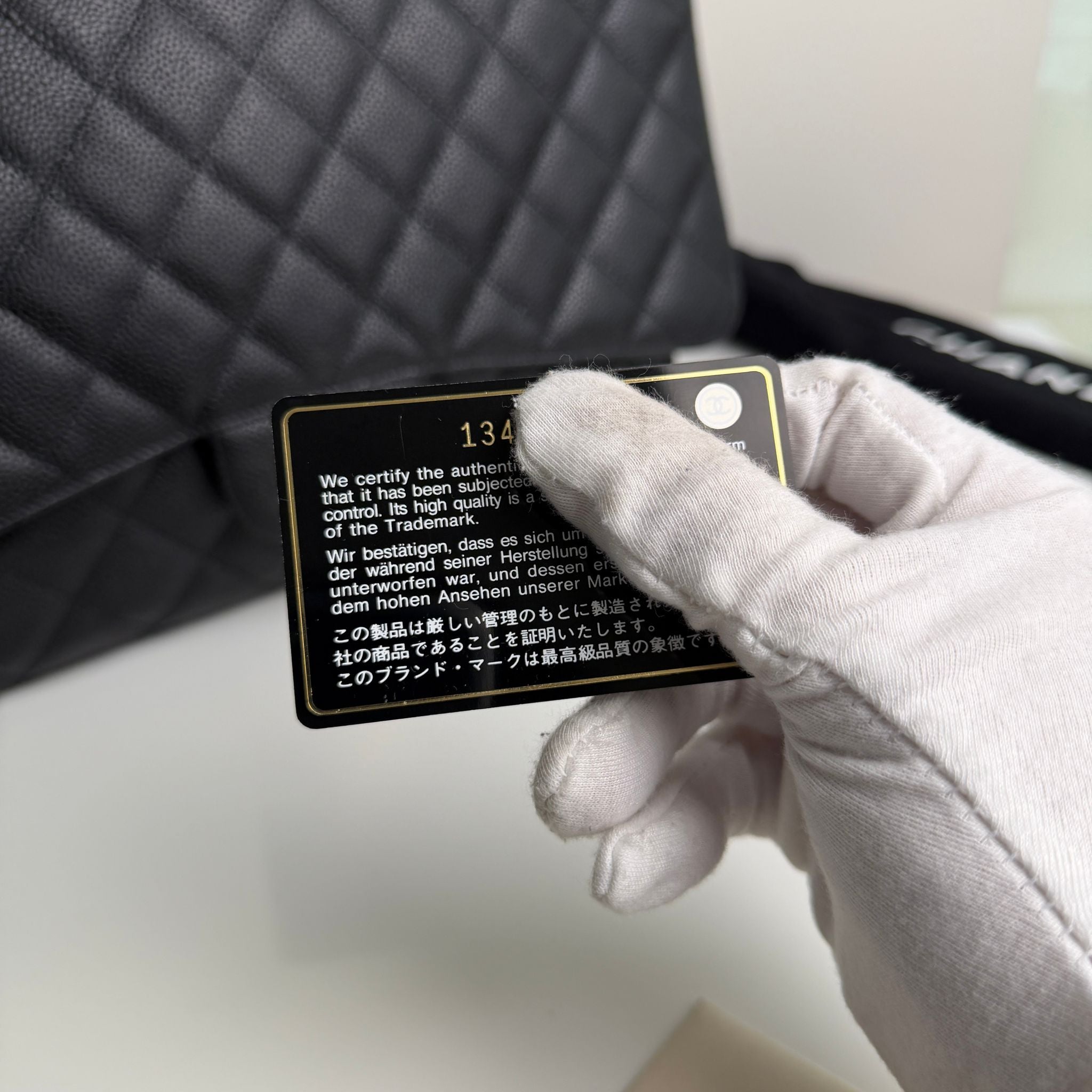 Hand holding a certification card with text against a blurred background