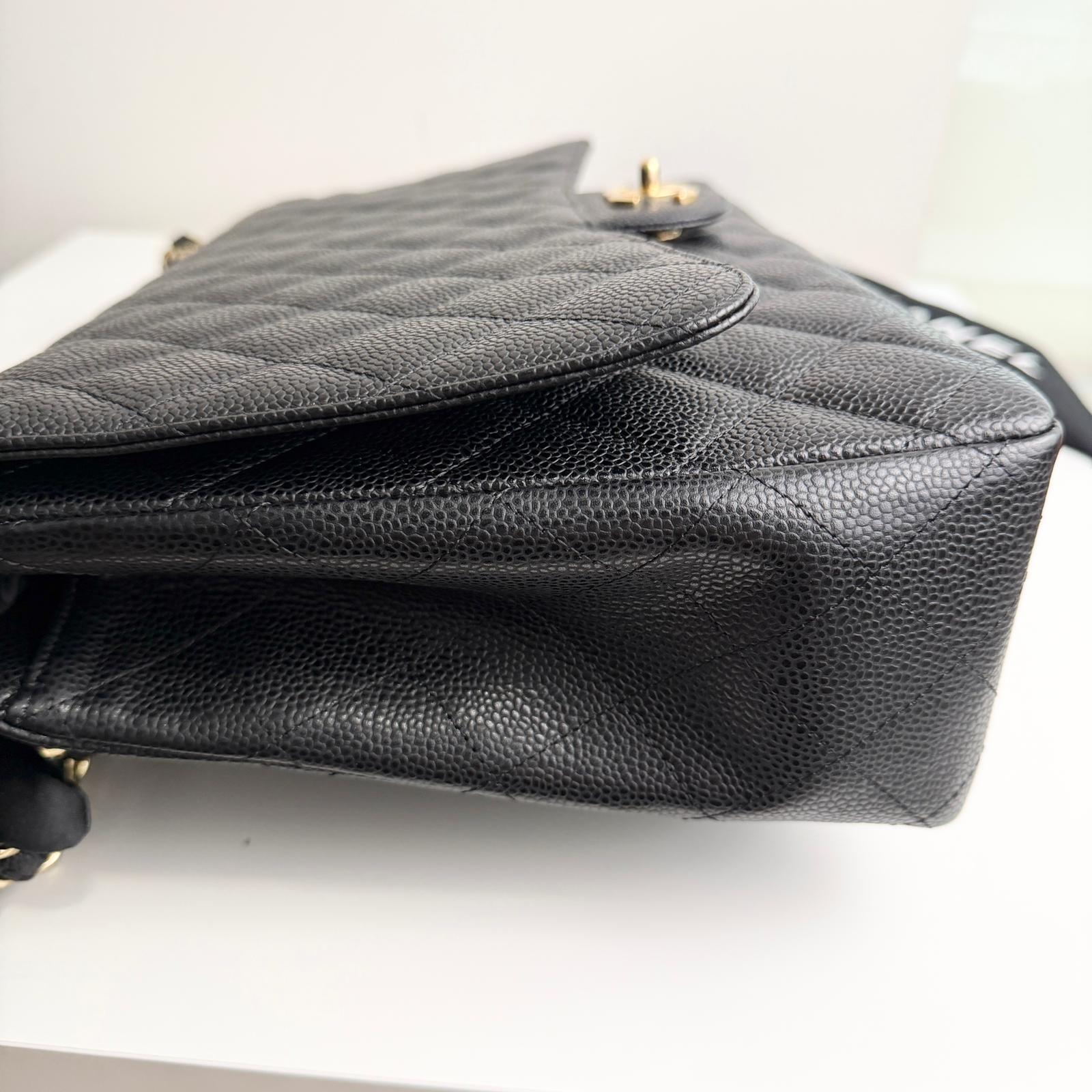 Black quilted handbag on a white background