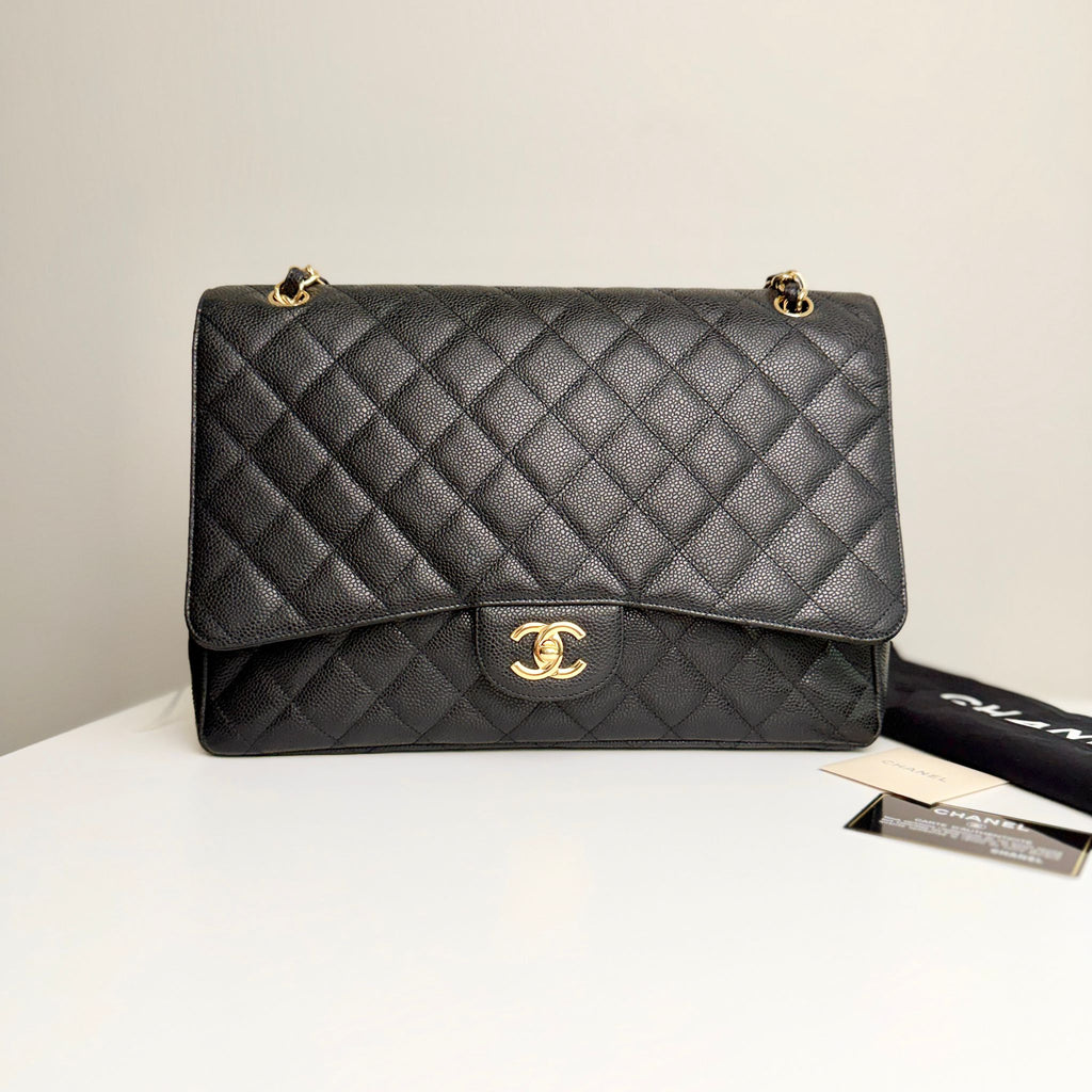 Black quilted Chanel handbag on a white surface with a beige background