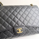 将图片加载到图库查看器，Gray quilted handbag with gold Chanel logo on a white background
