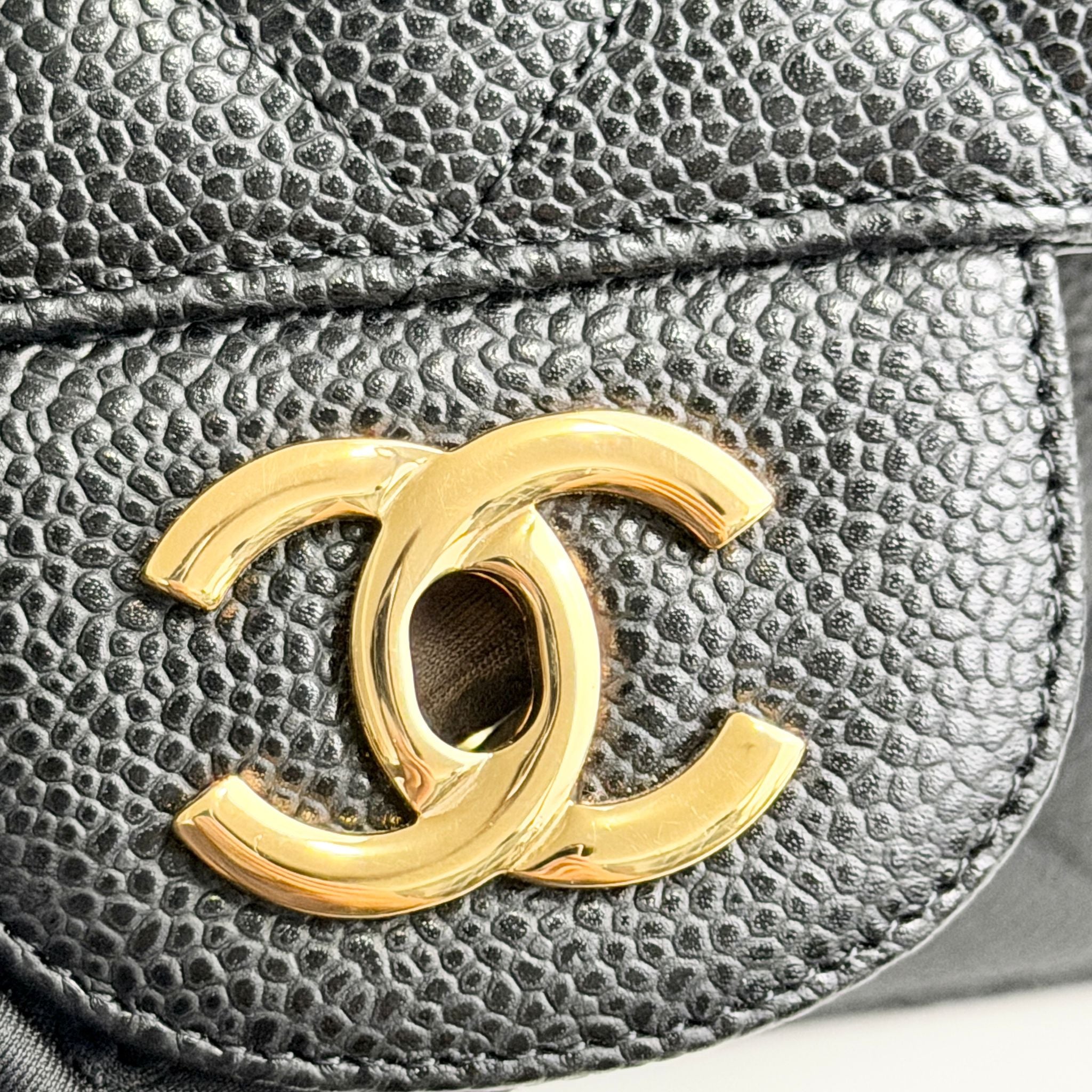 Close-up of a Chanel logo on a textured black surface