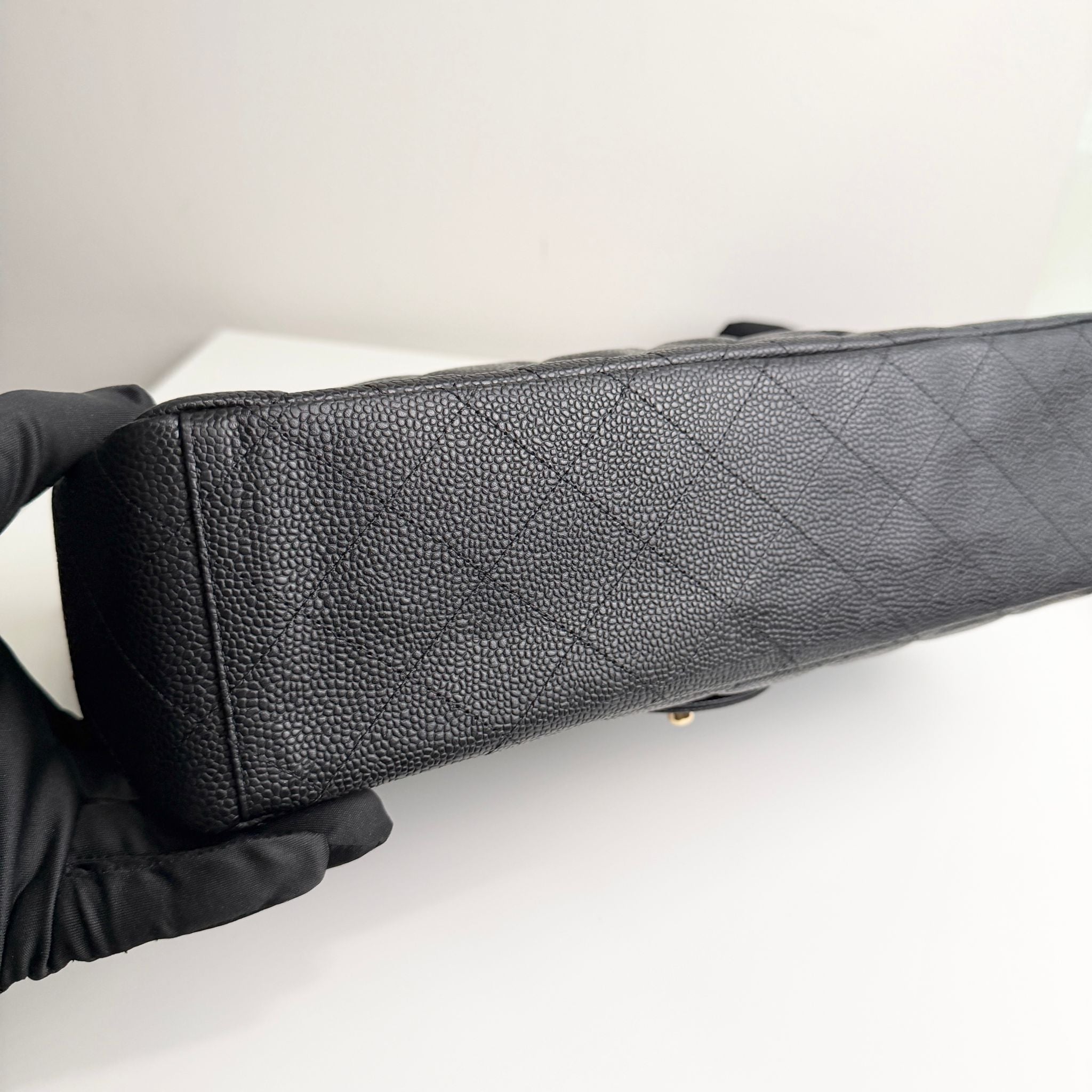 Black quilted handbag on a white surface