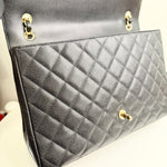 将图片加载到图库查看器，Close-up of a quilted black handbag with gold hardware on a neutral background
