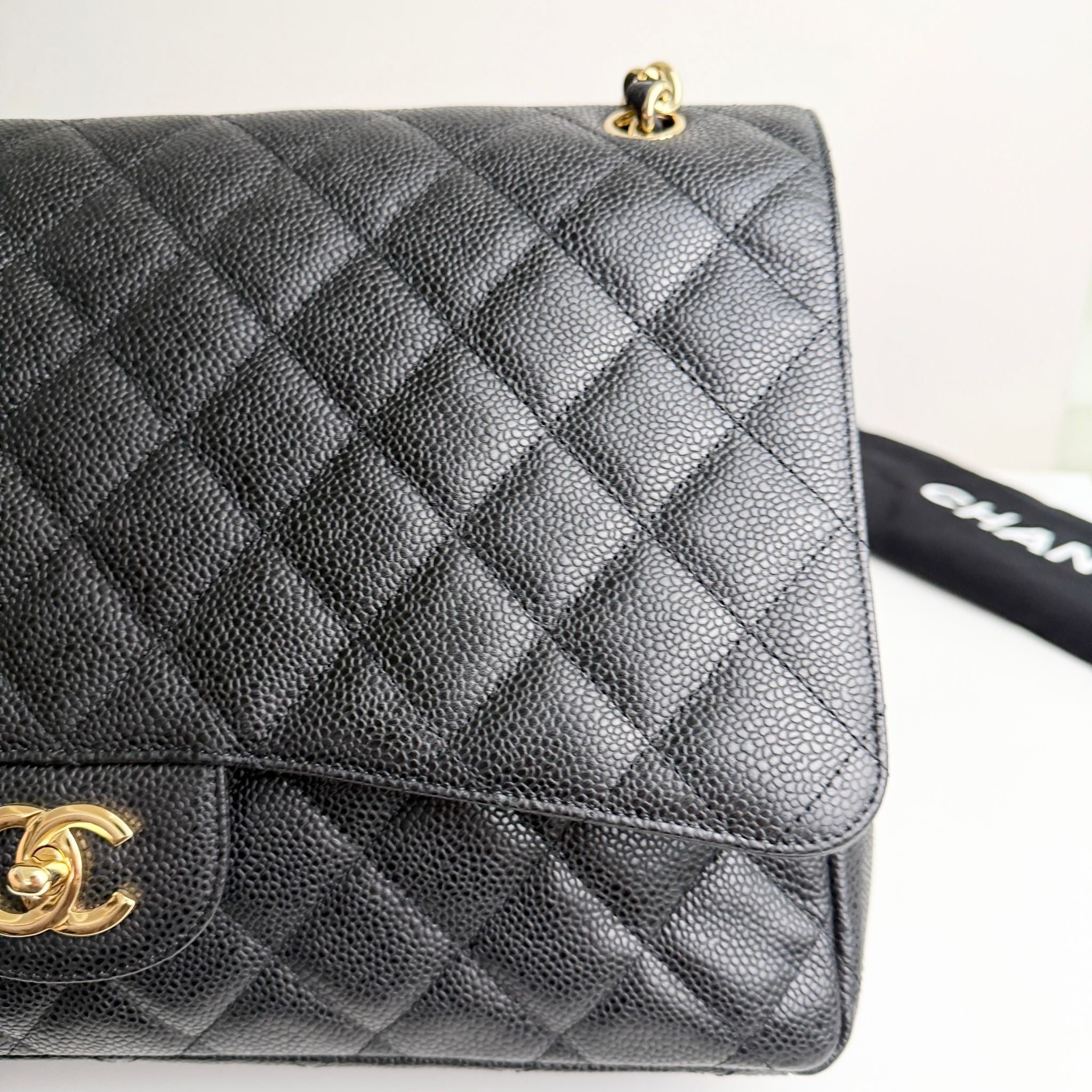 Gray quilted handbag with gold hardware on a white background