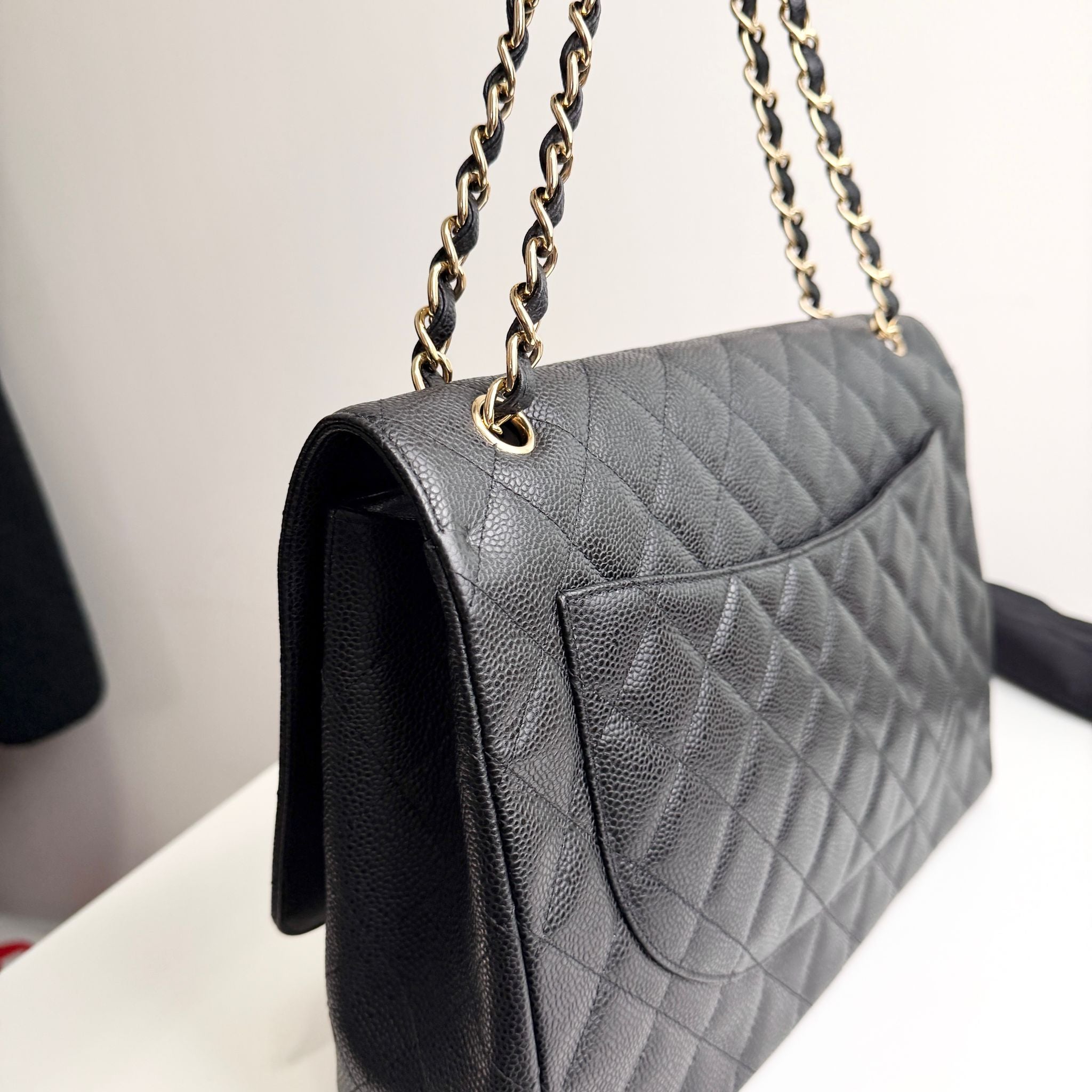 Gray quilted handbag with gold chain strap on a light background