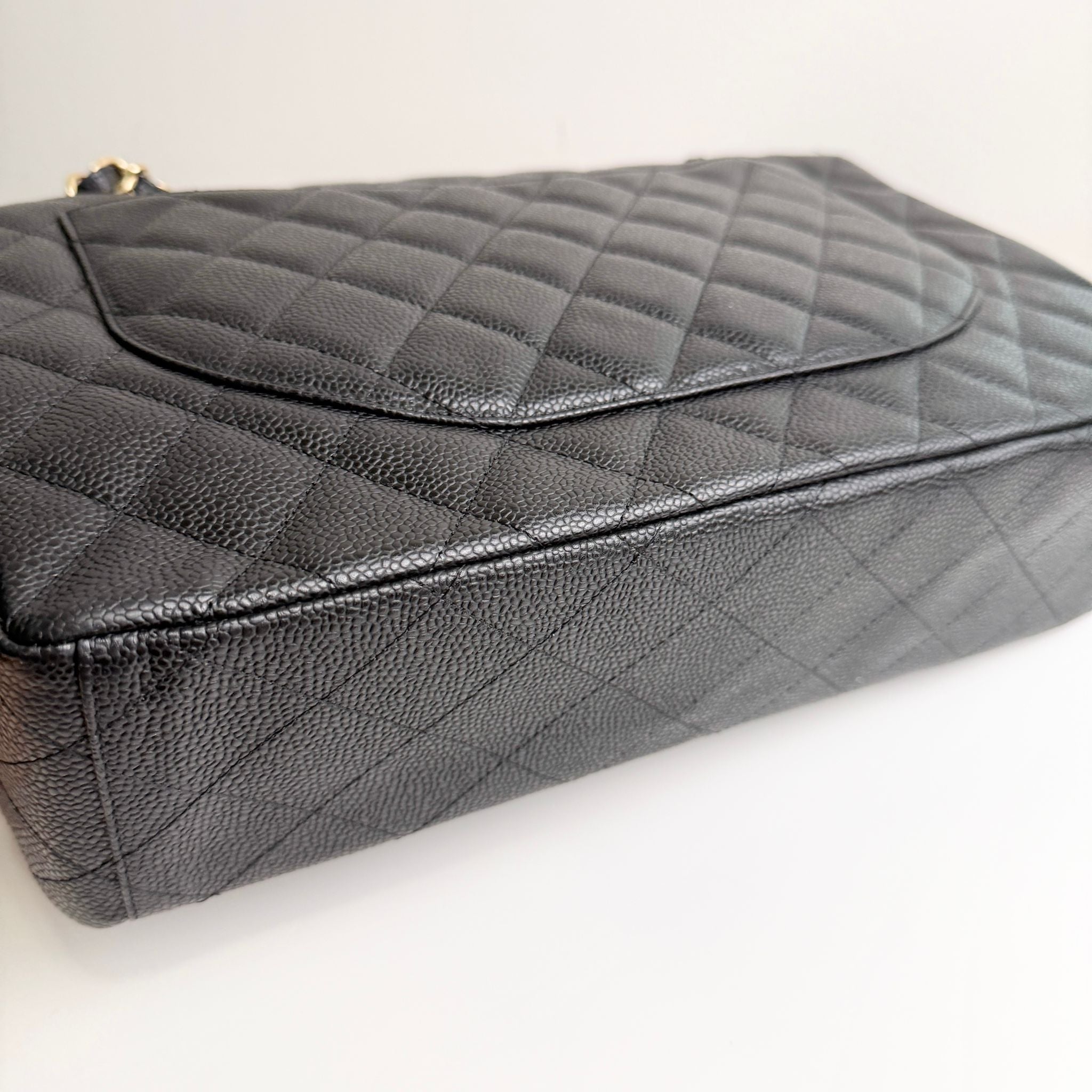 Quilted black handbag on a light gray background