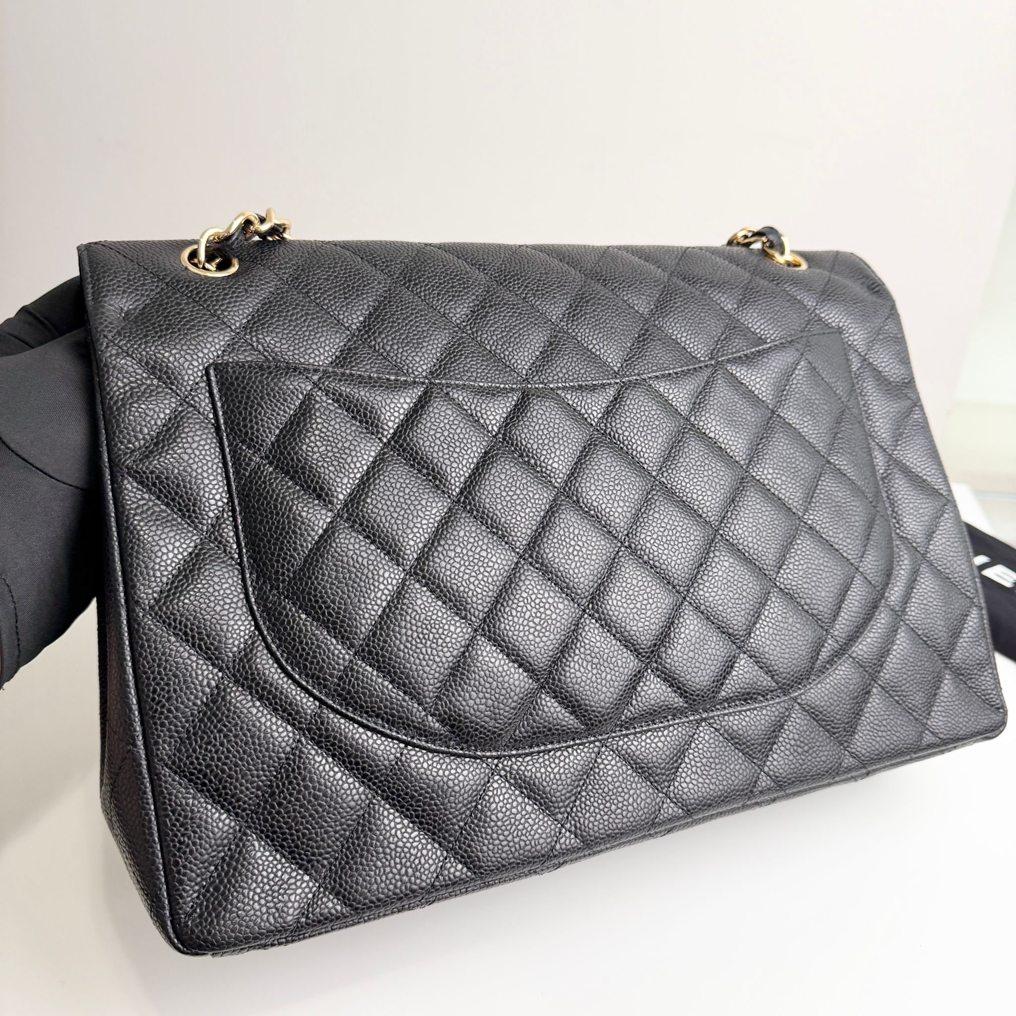 Quilted black handbag on a light gray background