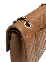 将图片加载到图库查看器，Close-up of a brown quilted handbag with a gold chain detail on a white background
