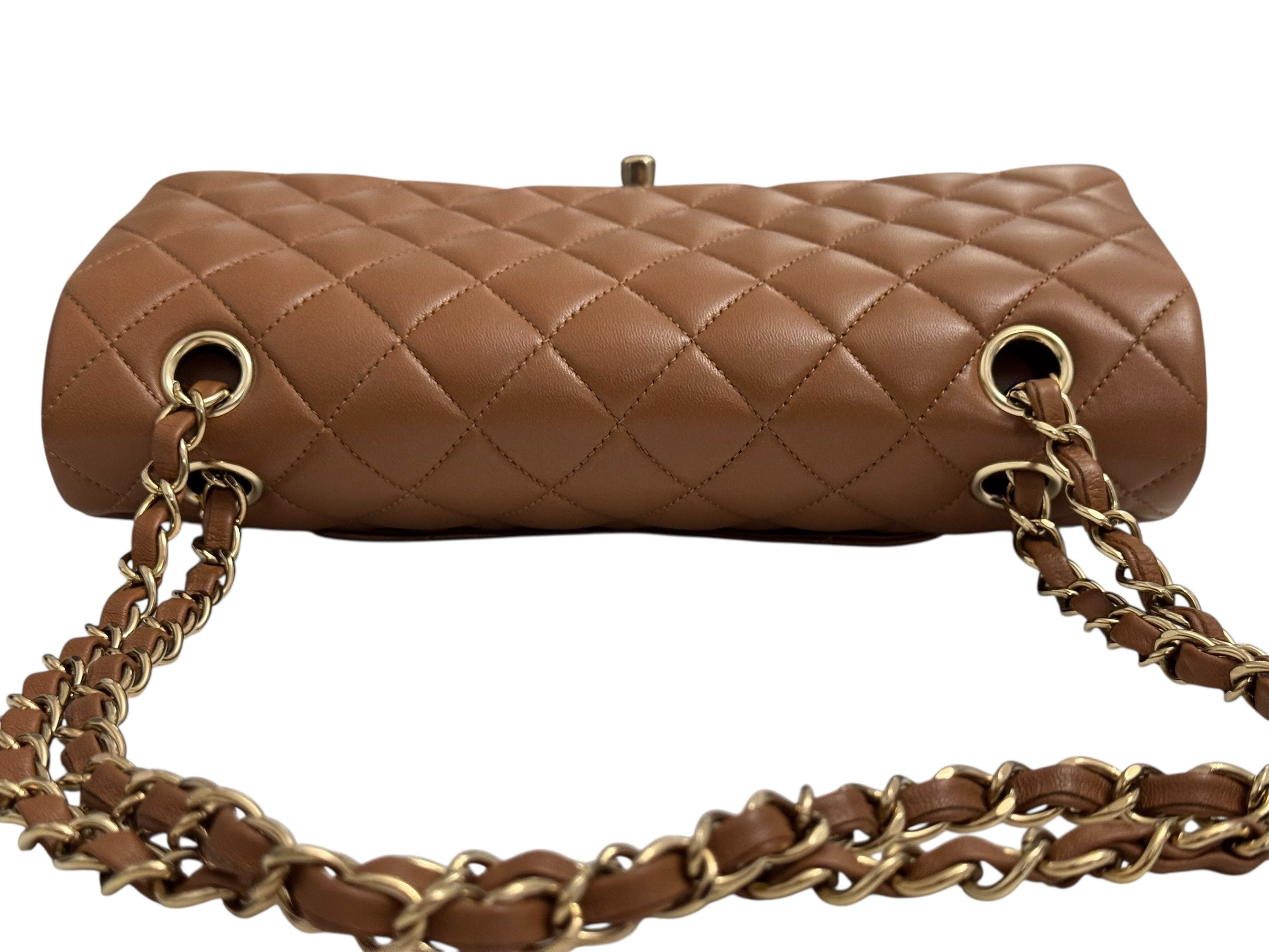 Brown quilted handbag with gold chain strap on a white background