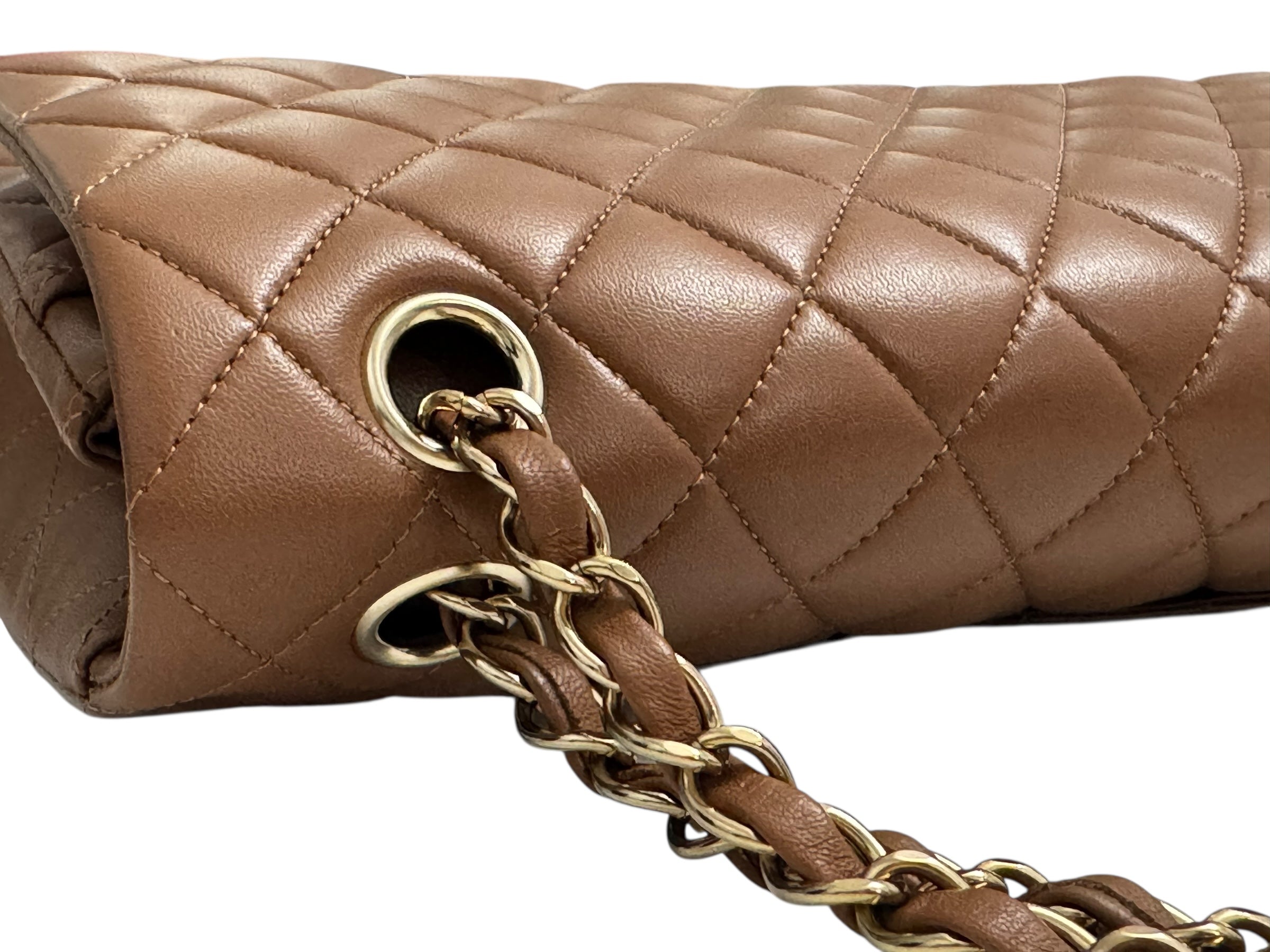 Brown quilted handbag with gold chain strap on a white background