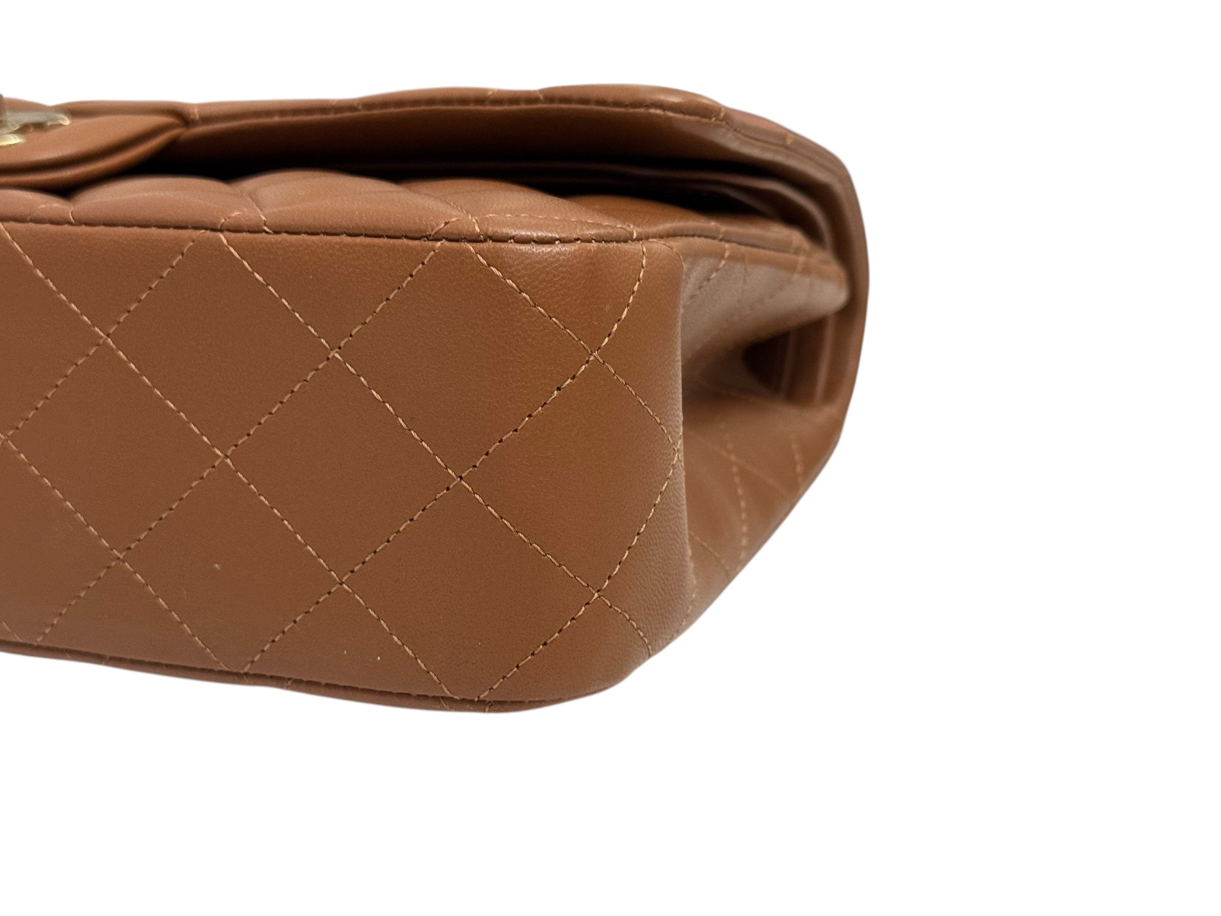 Close-up of a brown quilted handbag on a white background