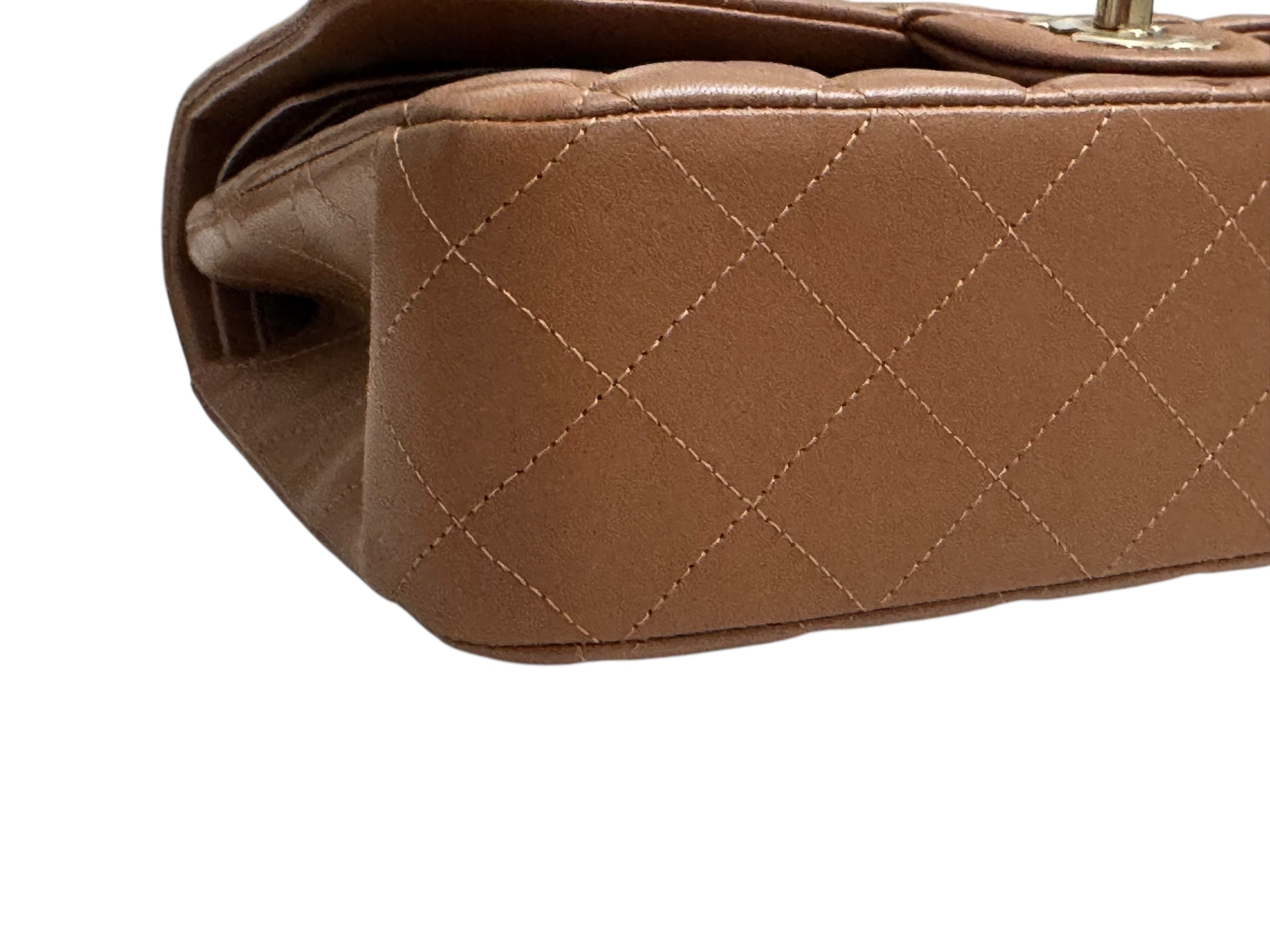 Close-up of a brown quilted handbag on a white background