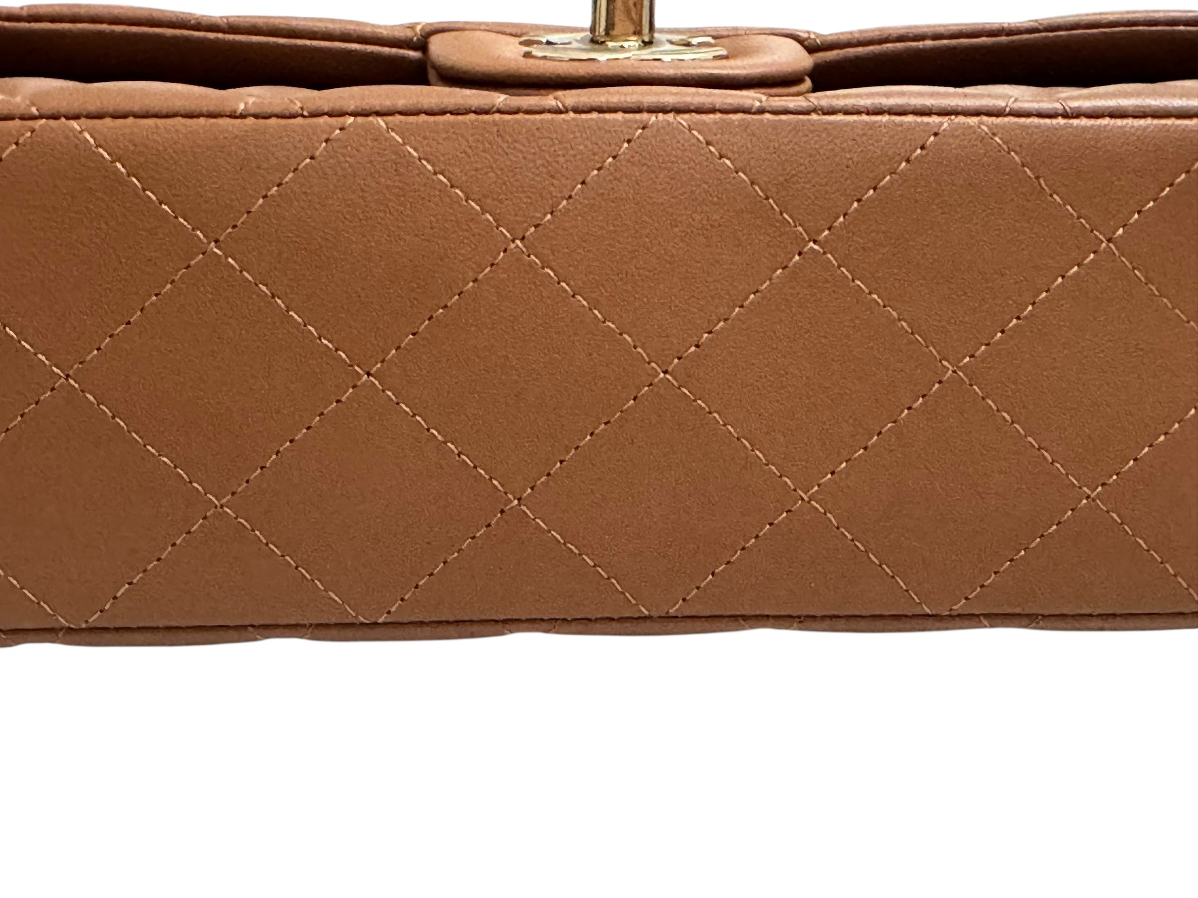 Close-up of a brown quilted handbag with a white background