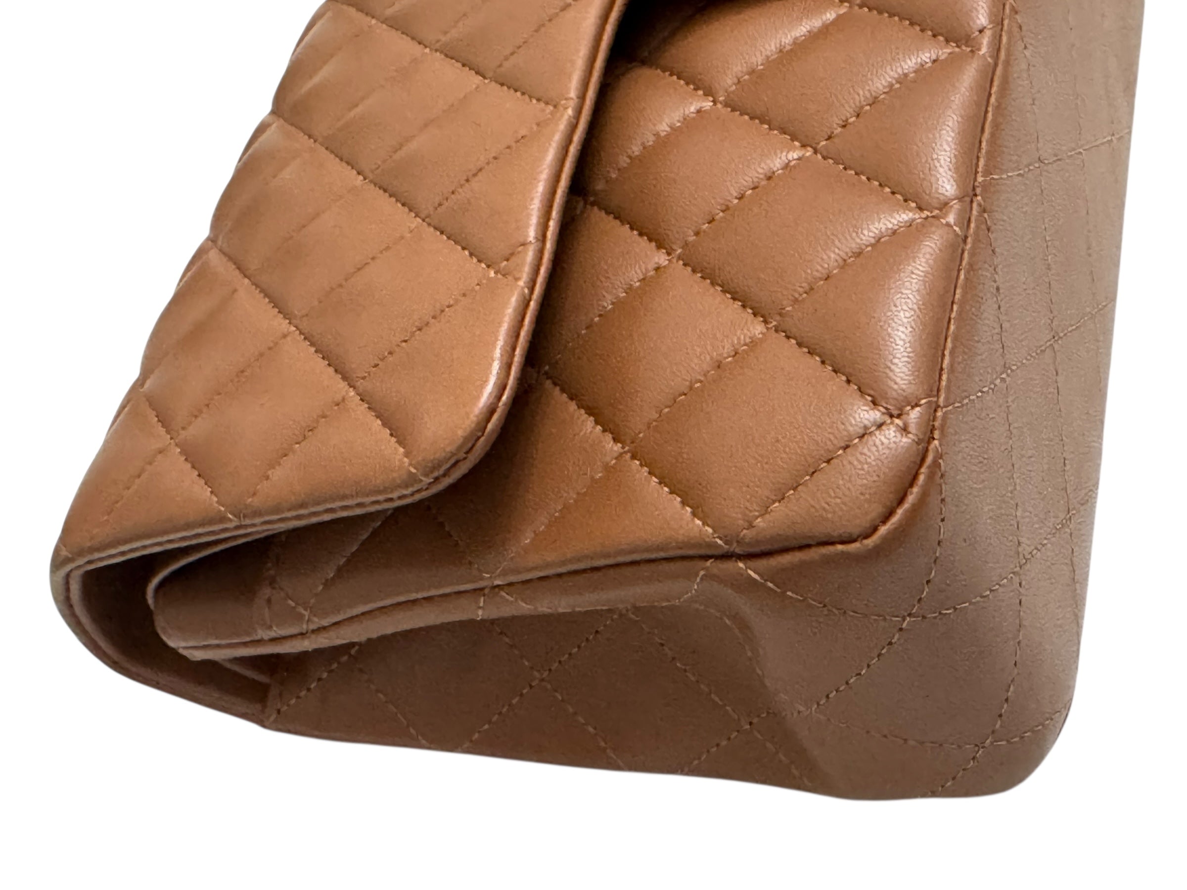 Close-up of a brown quilted handbag on a white background