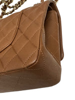 将图片加载到图库查看器，Close-up of a brown quilted handbag with a gold chain strap on a white background
