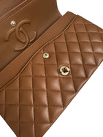 将图片加载到图库查看器，Close-up of a brown quilted handbag with gold hardware on a white background
