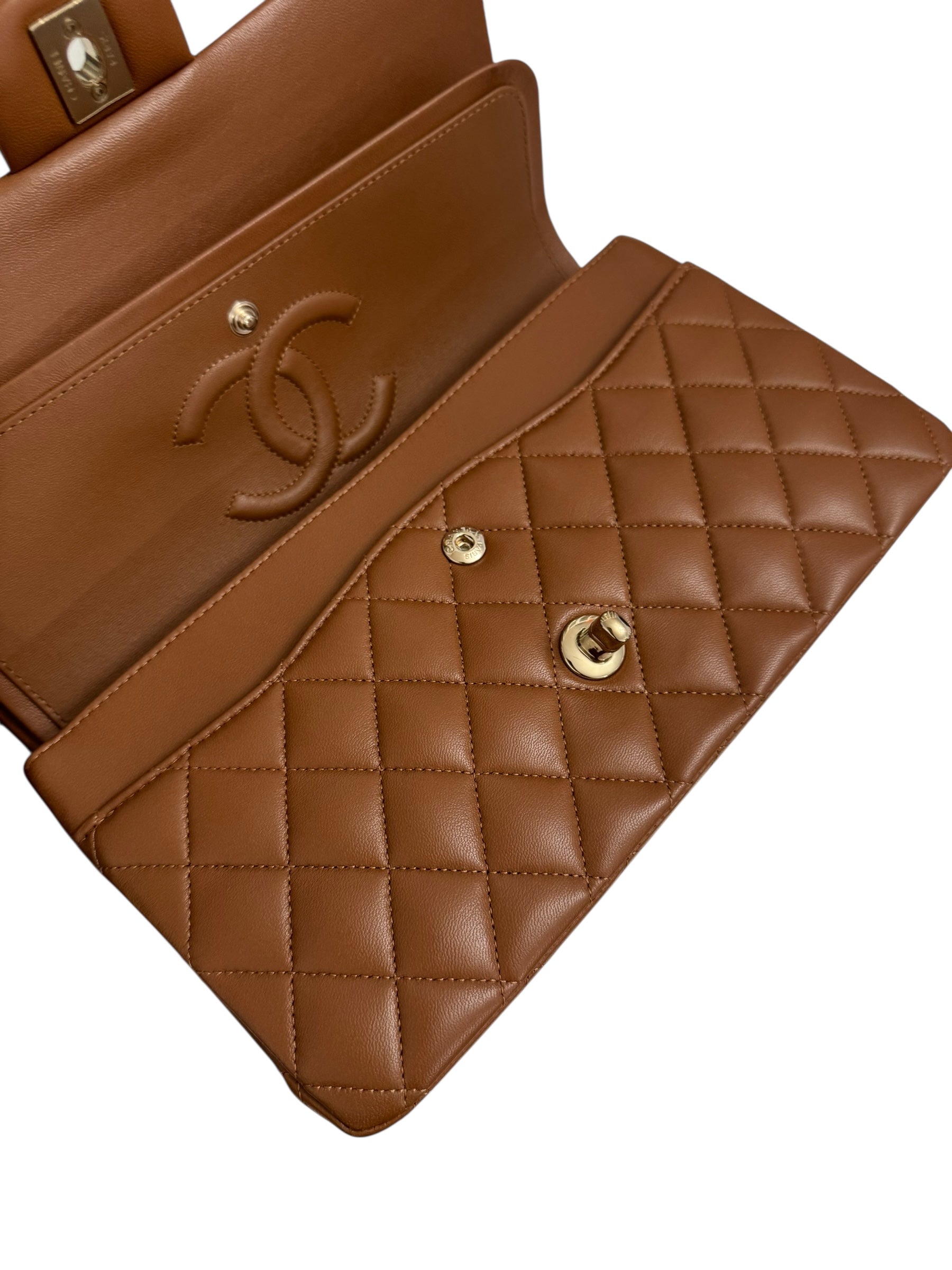 Brown quilted handbag with gold hardware on a white background