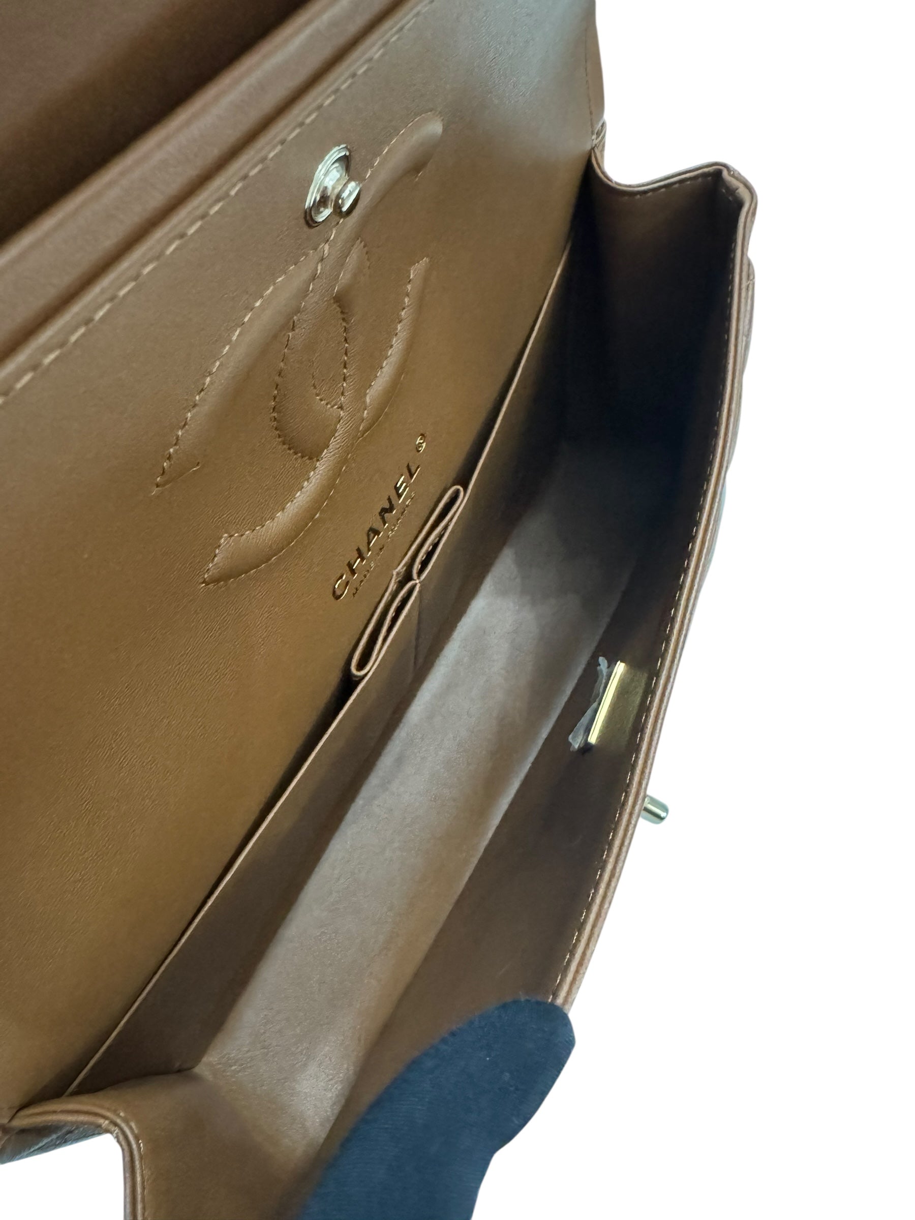 Close-up of a brown leather handbag with visible Chanel logo.