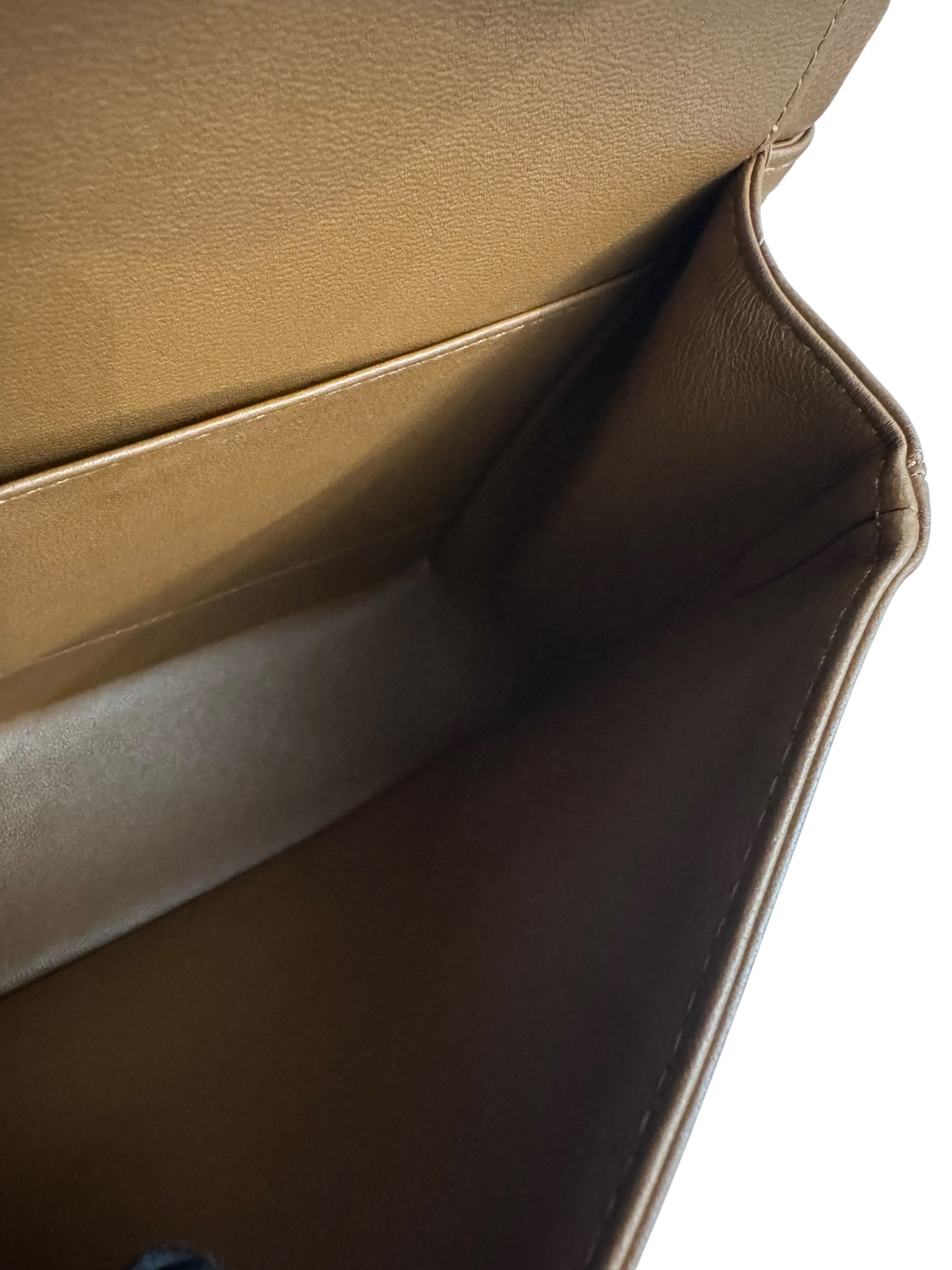 Close-up of a brown leather bag with a white background