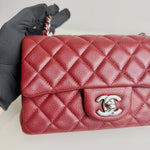 将图片加载到图库查看器，Red quilted handbag with silver clasp held by a gloved hand on a light background
