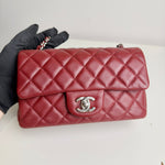 将图片加载到图库查看器，Red quilted handbag with Chanel logo held by a gloved hand on a white background
