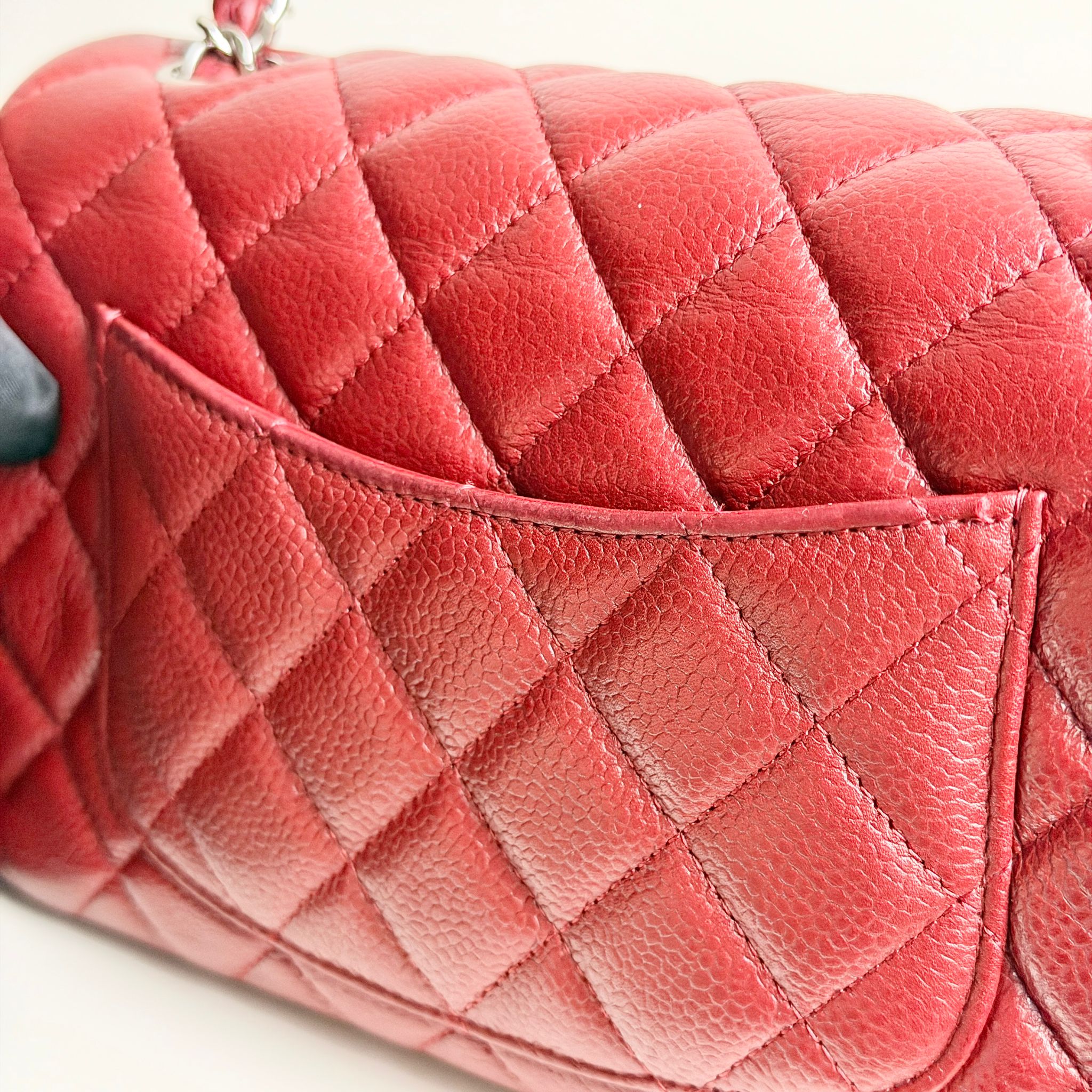 Close-up of a red quilted handbag with a white background