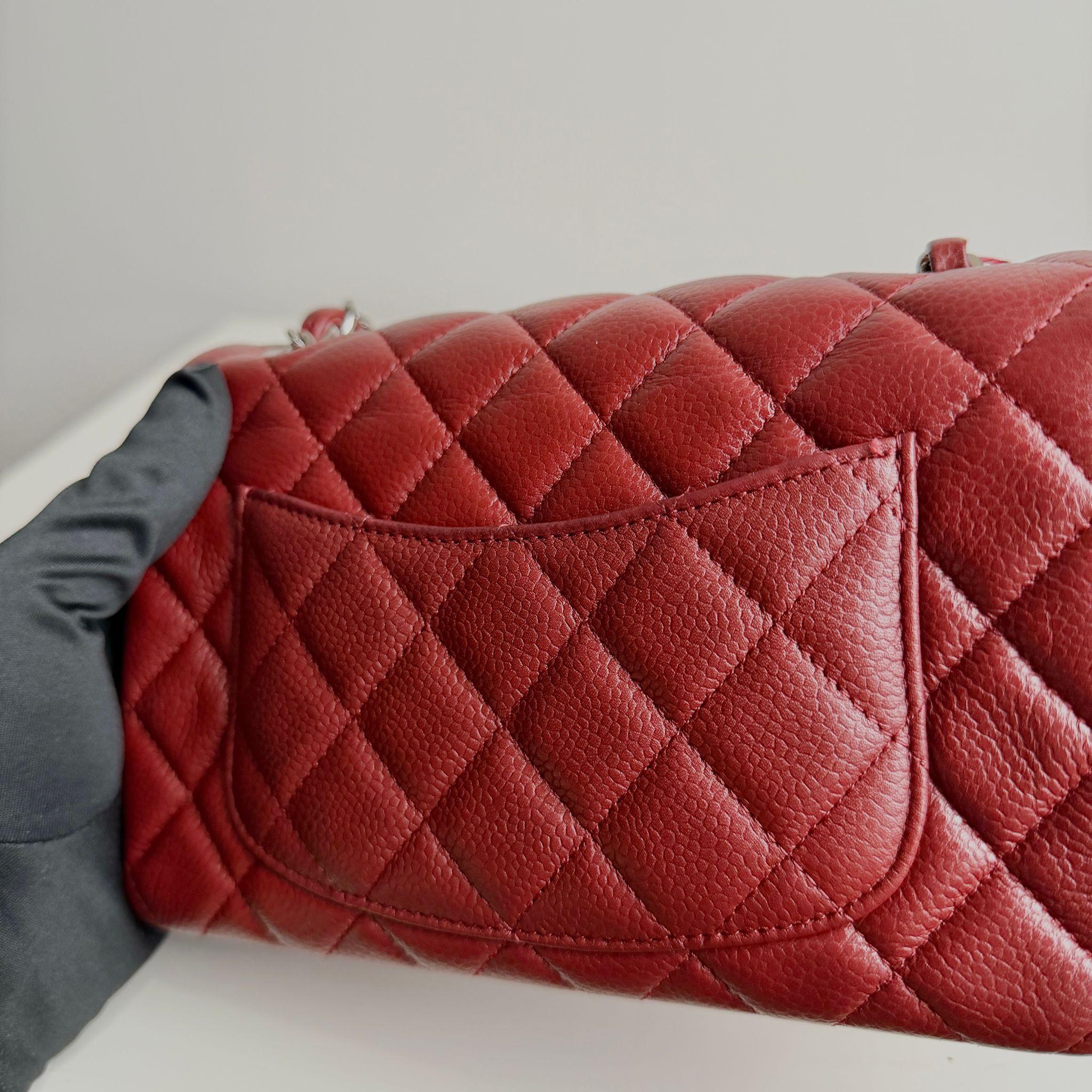 Red quilted handbag on a light gray surface