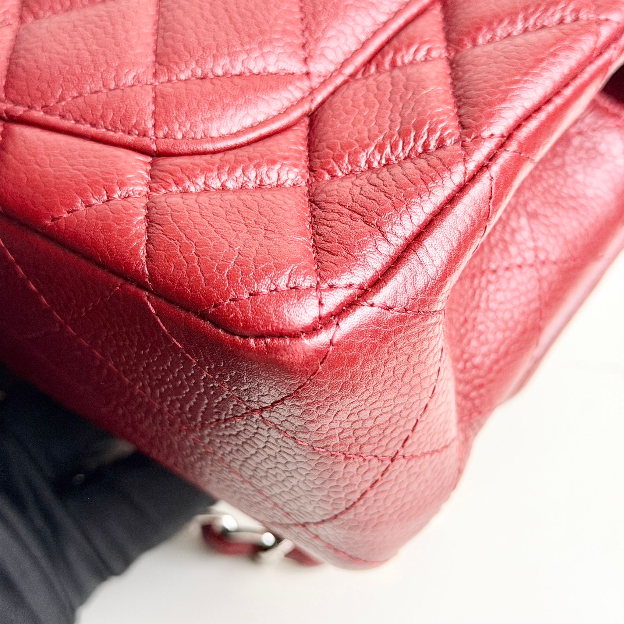 Close-up of a red quilted handbag with a blurred background