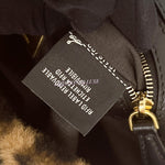 将图片加载到图库查看器，Close-up of a branded tag on a black leather product with gold zipper.
