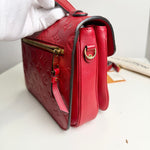 Load image into Gallery viewer, Red handbag with gold accents held by a gloved hand on a white surface.
