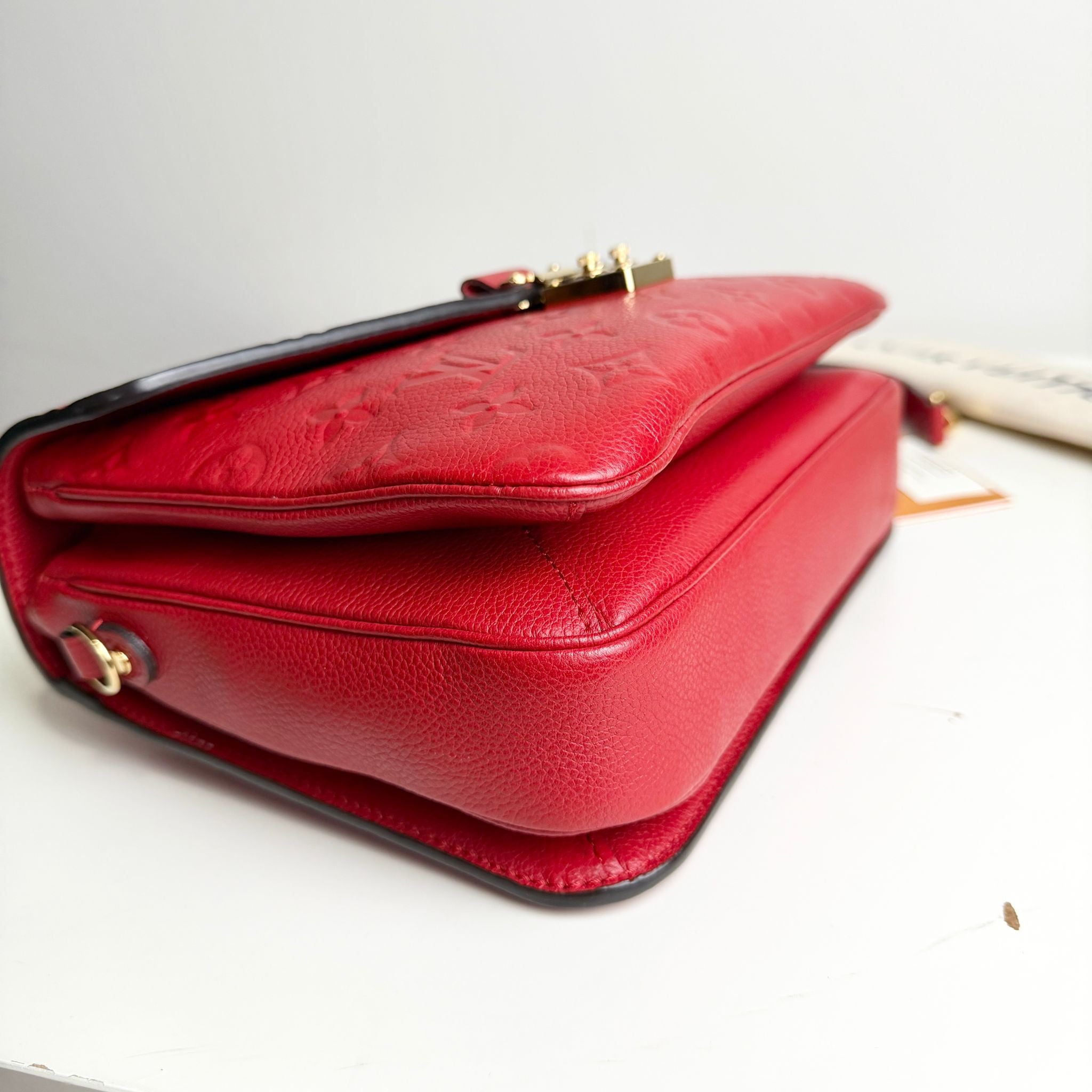 Red handbag with gold accents on a white background