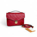 Load image into Gallery viewer, Red handbag with monogram pattern and matching strap on a white background
