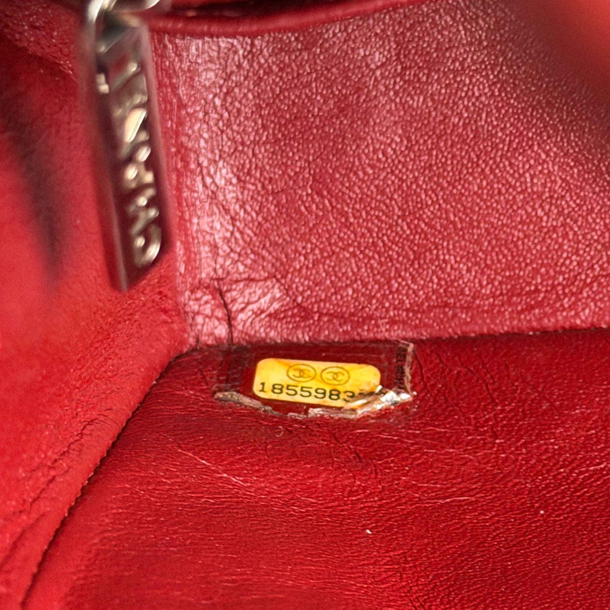 Close-up of a red leather bag with a visible brand tag.