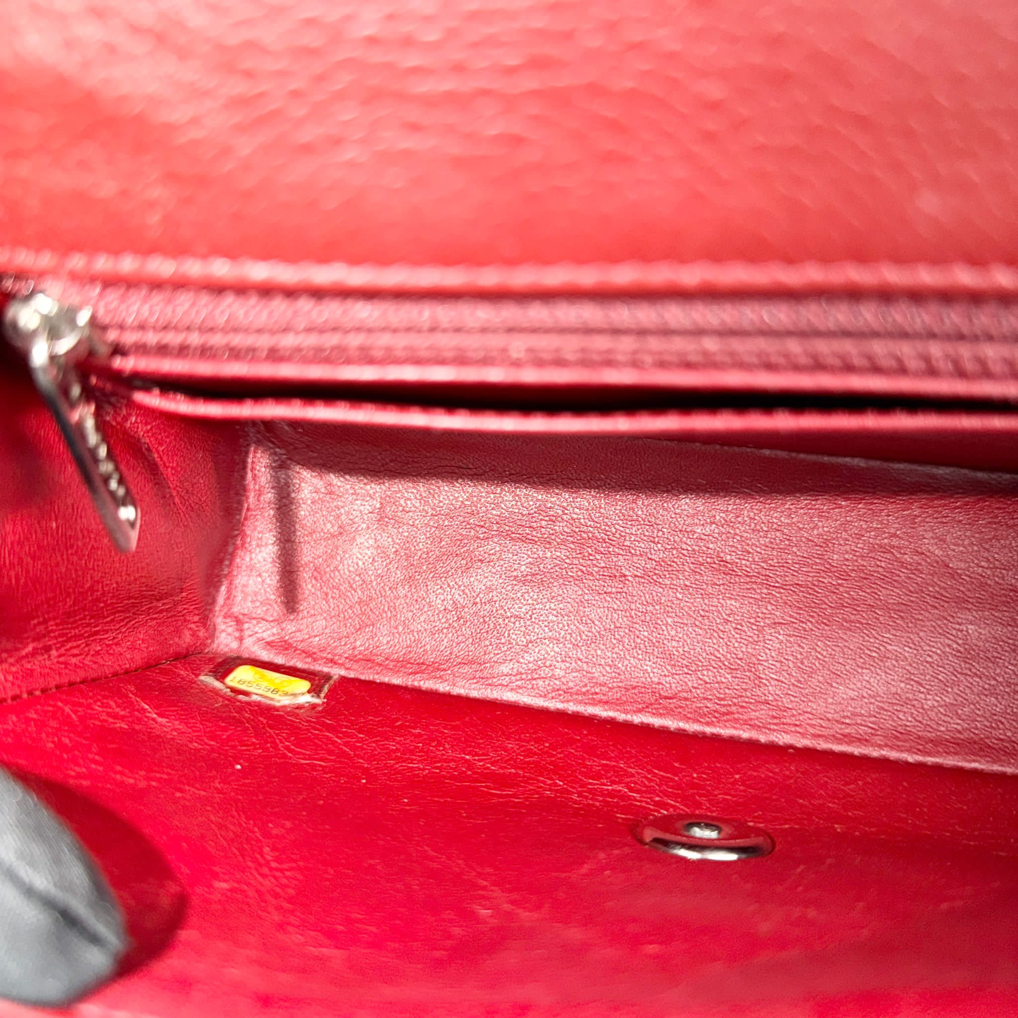 Close-up of a red leather handbag with a zipper