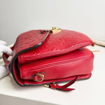 Load image into Gallery viewer, Red leather handbag with gold accents on a light gray background
