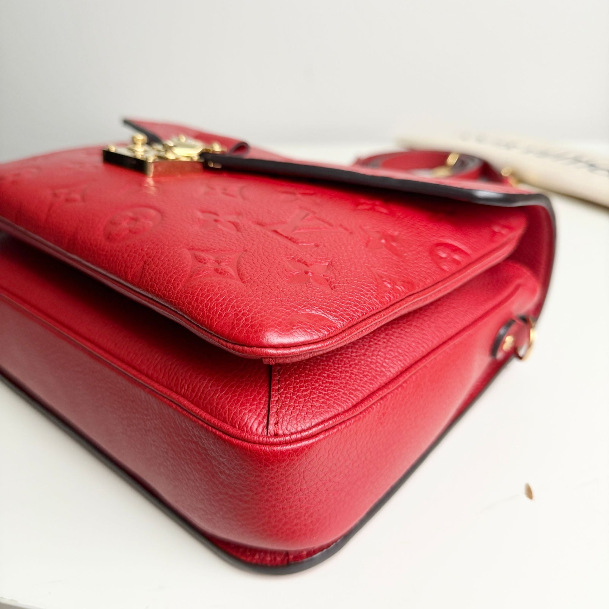 Red handbag with gold clasp on a white background
