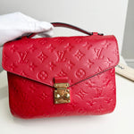 Load image into Gallery viewer, Red handbag with gold lock held by a gloved hand on a white background
