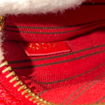 Load image into Gallery viewer, Close-up of a red fabric with gold zipper and &#39;Guess&#39; brand label.
