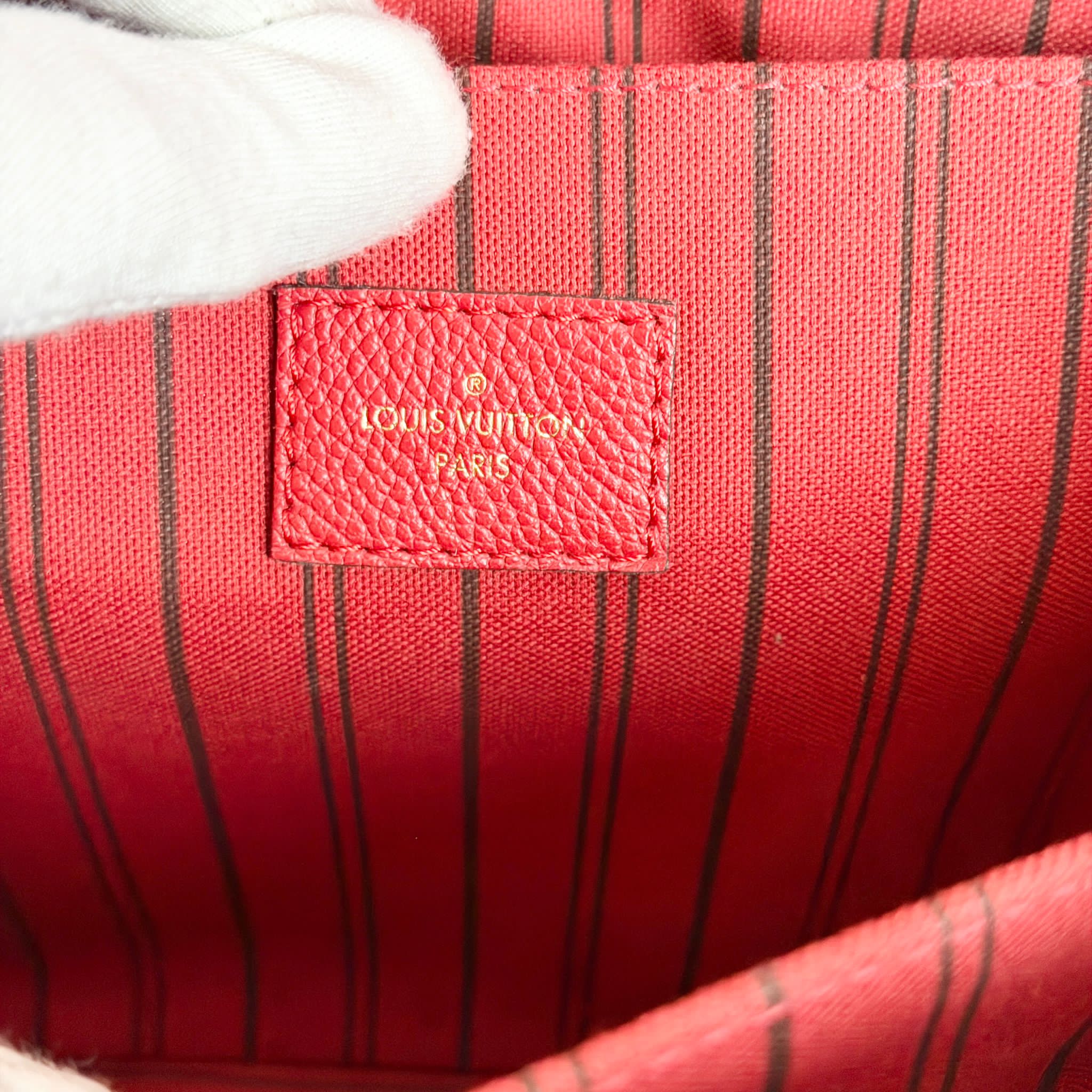 Close-up of a red Louis Vuitton bag with a visible logo.